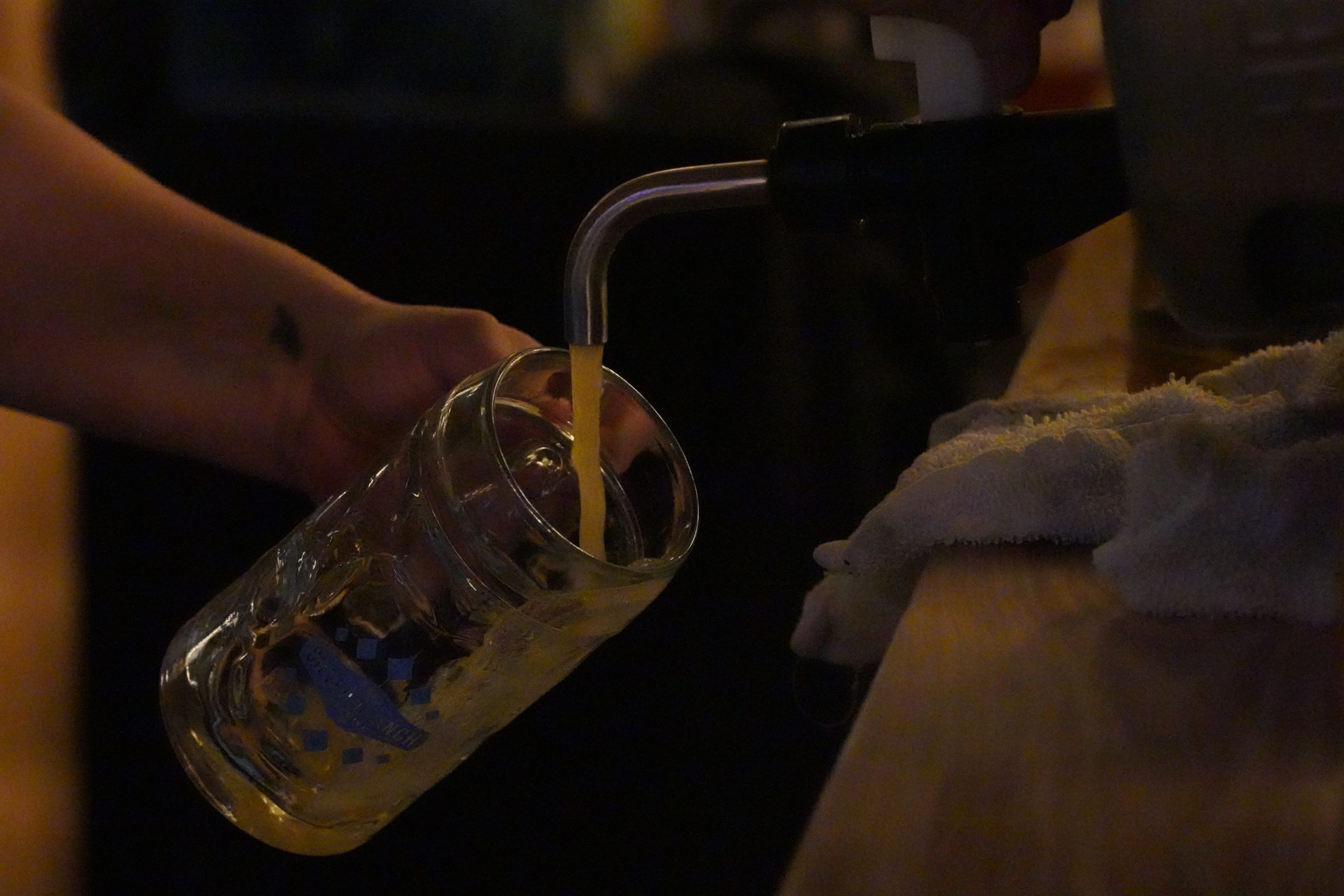 A server taking a pour from the keg.